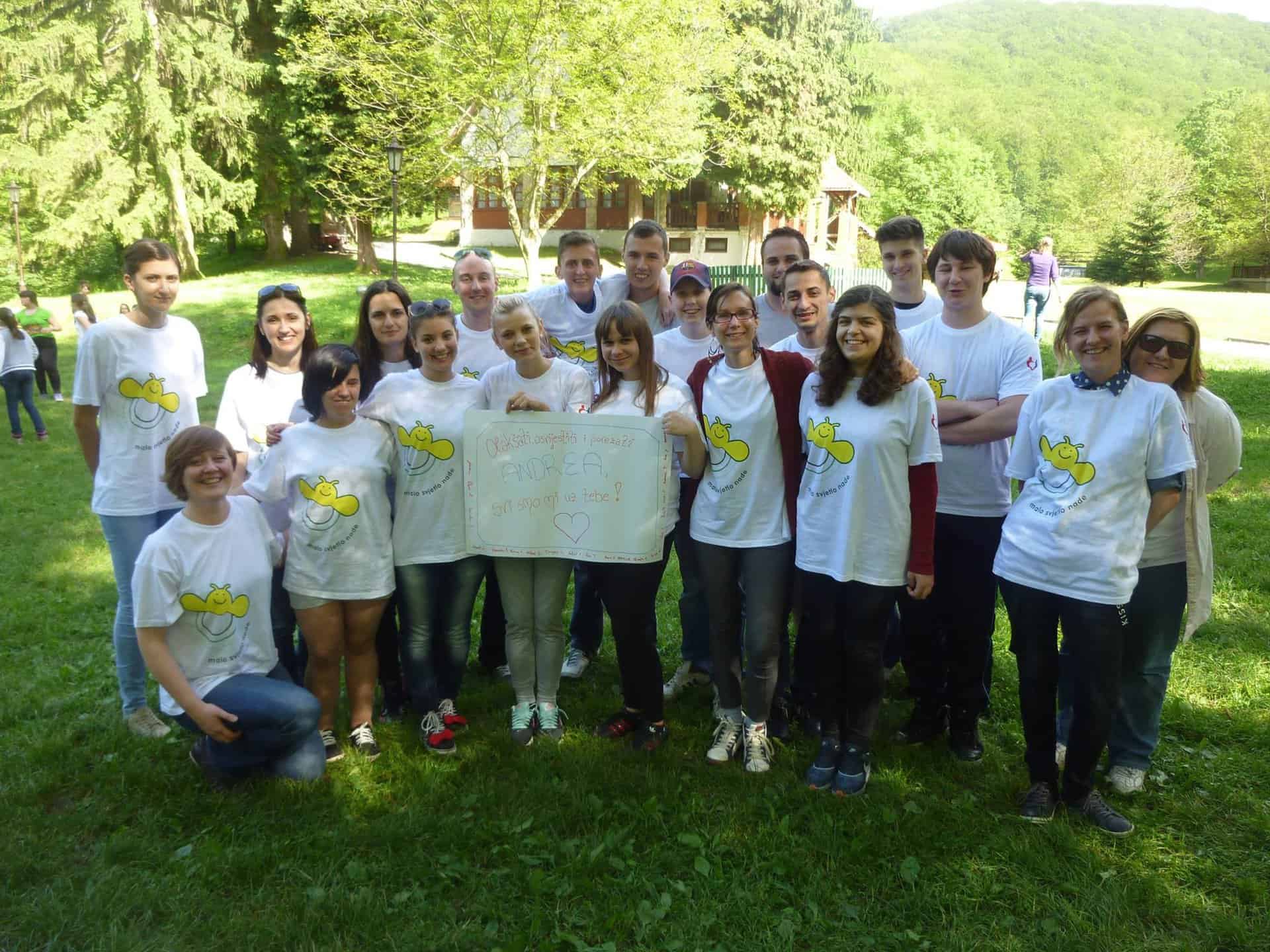 Grupa ljudi sa istim majicama u prirodi.