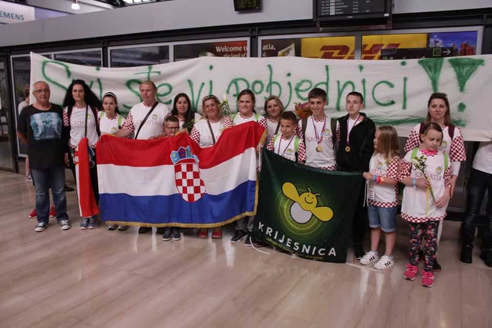 Grupa ljudi s hrvatskim zastavama i transparentom.